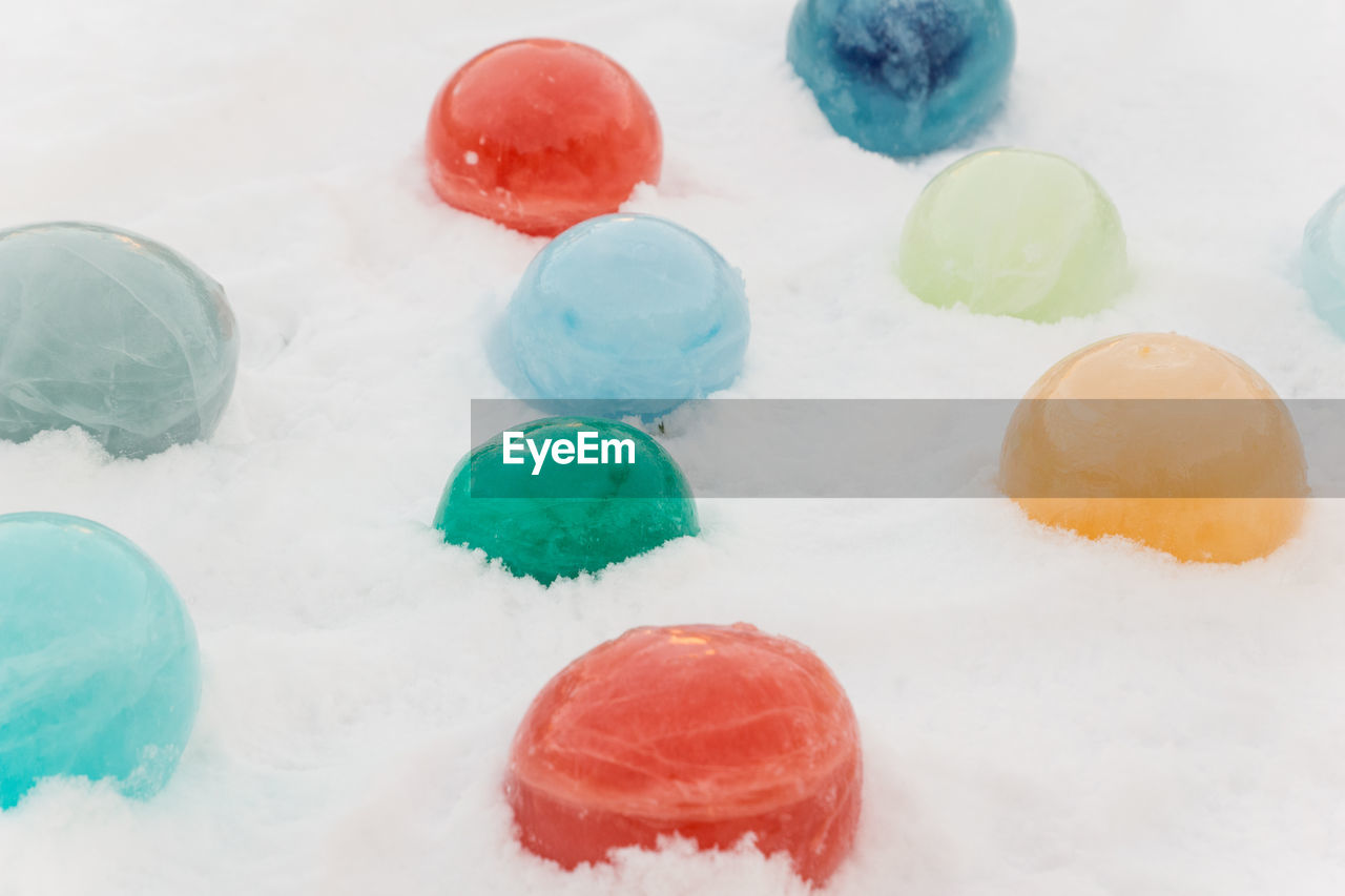 Coloured ice marbles in the snow