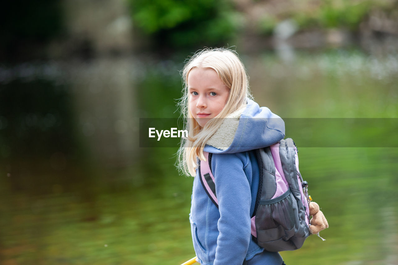 Portrait of girl standing against lake