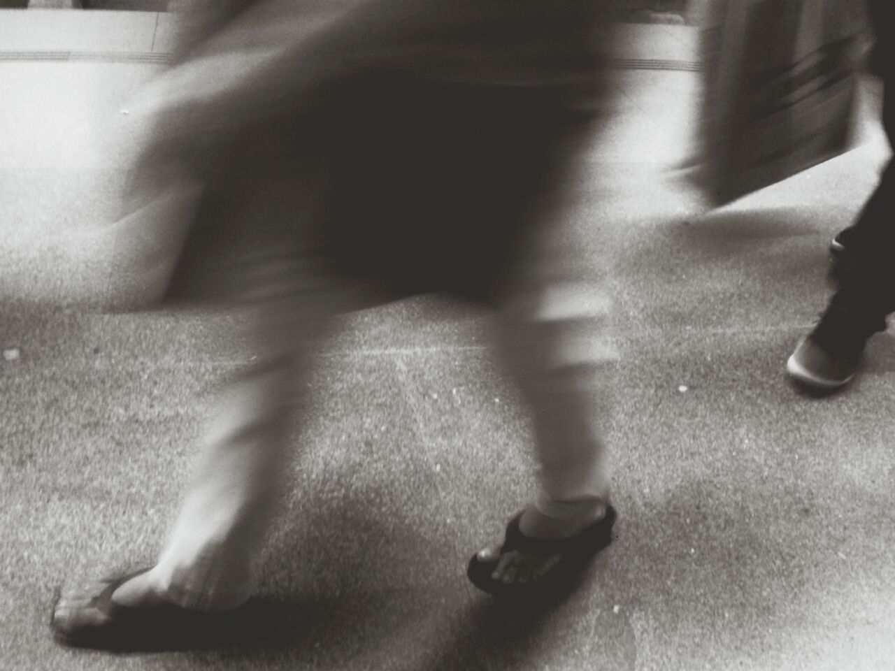 Blurred image of people walking on sidewalk