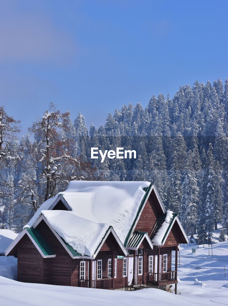 HOUSES ON SNOW COVERED LAND AGAINST SKY