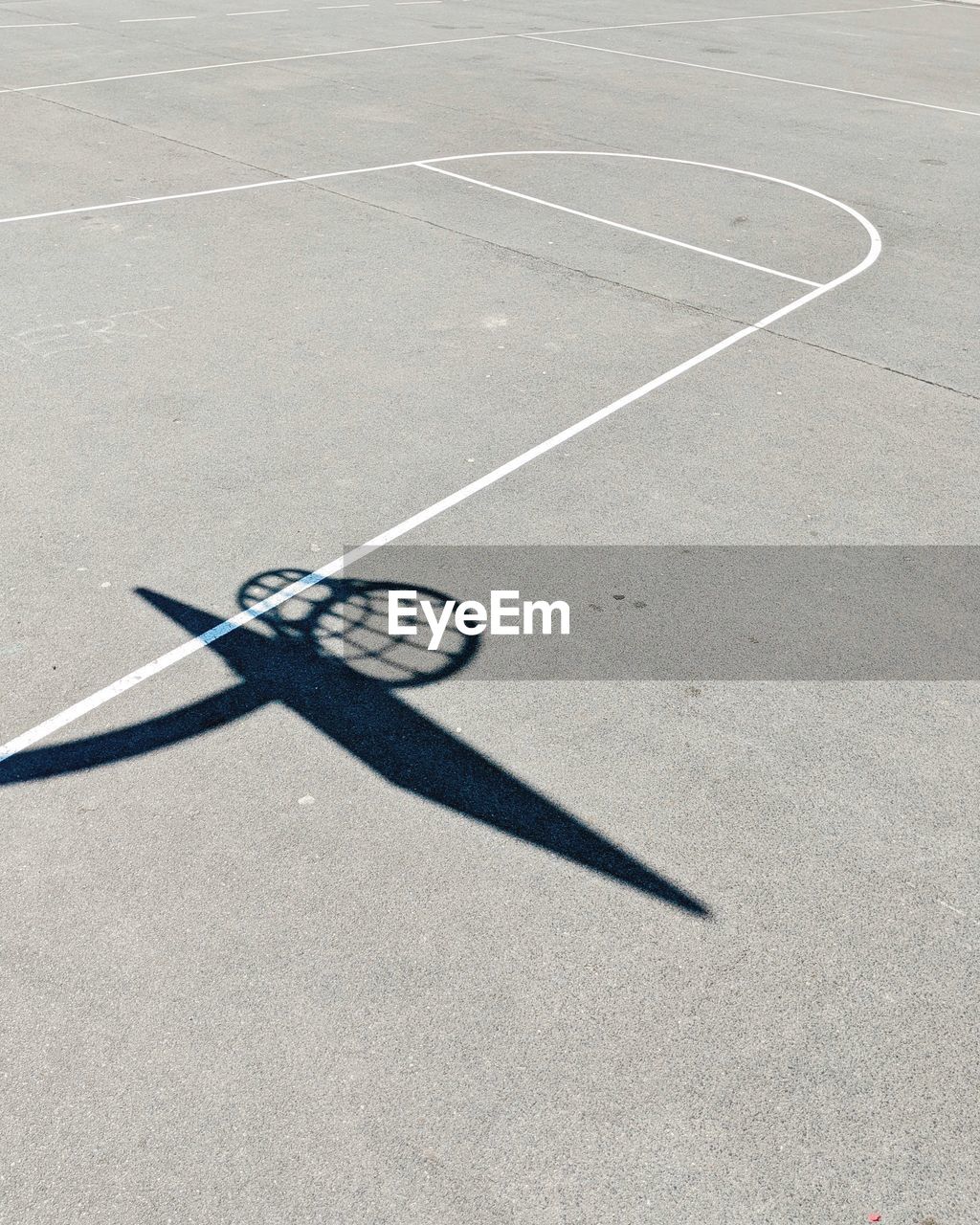 Shadow of basketball hoop on ground
