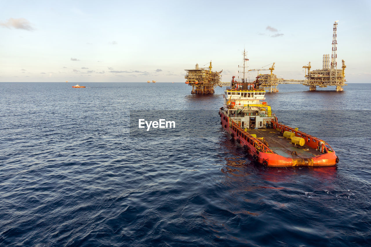 An anchor handling tug boat maneuvering at offshore oil production platform 