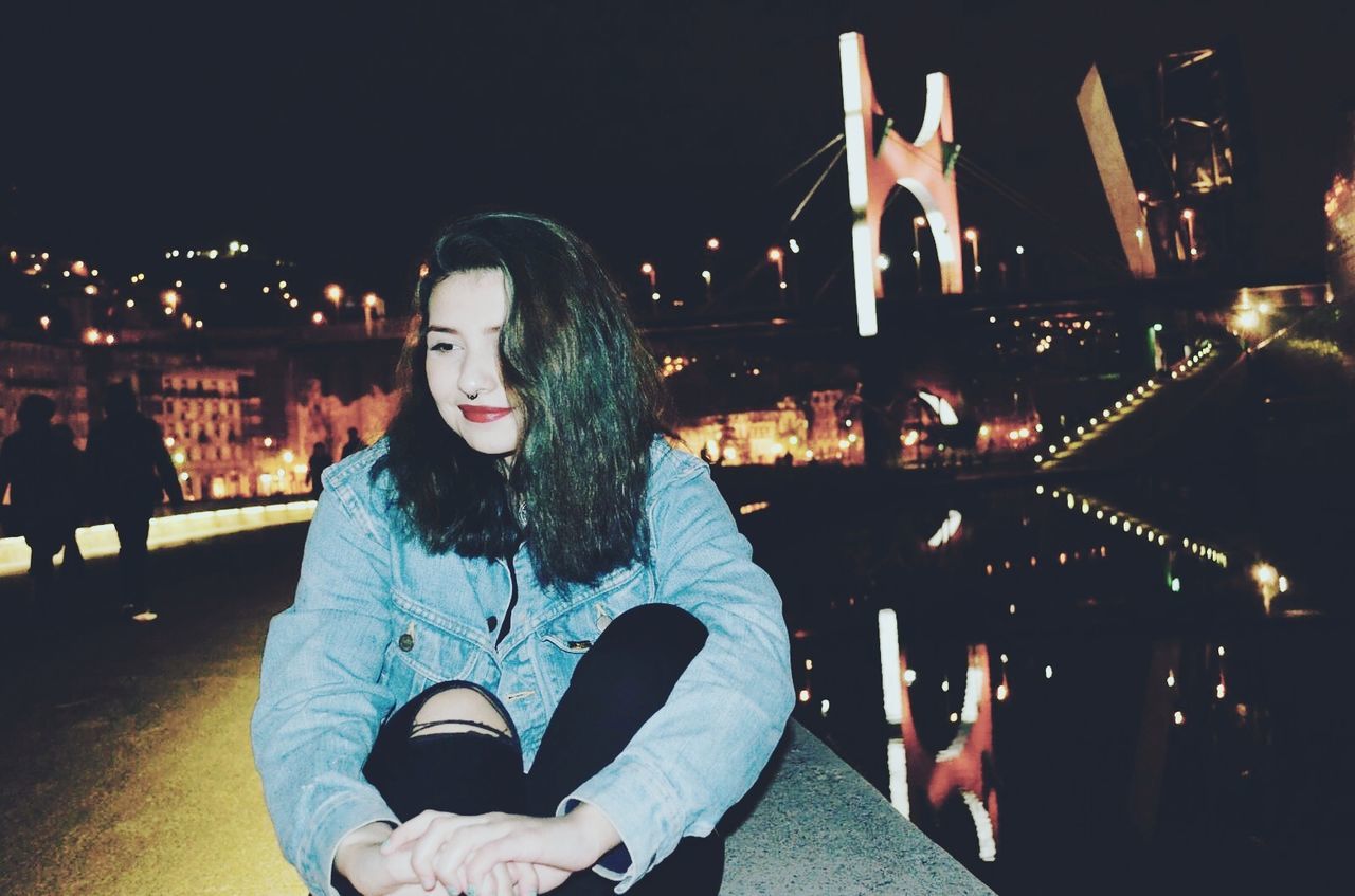 Young woman in city at night