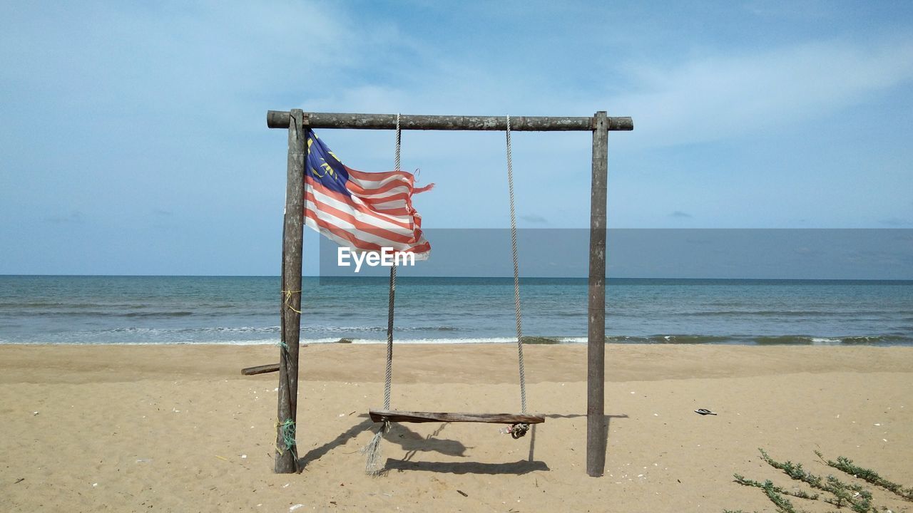 Flag on beach against sky