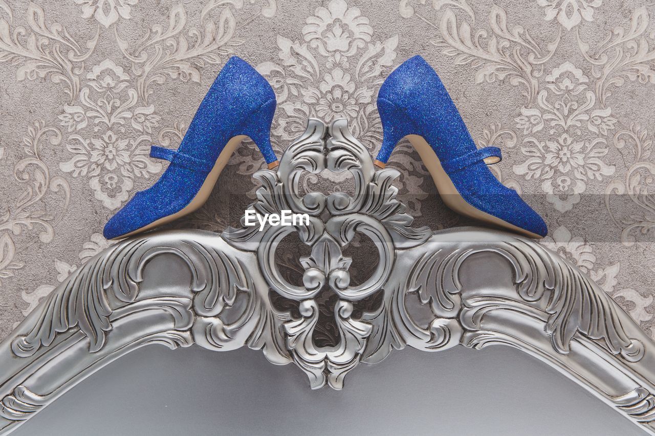 Close-up of blue high heels by wall