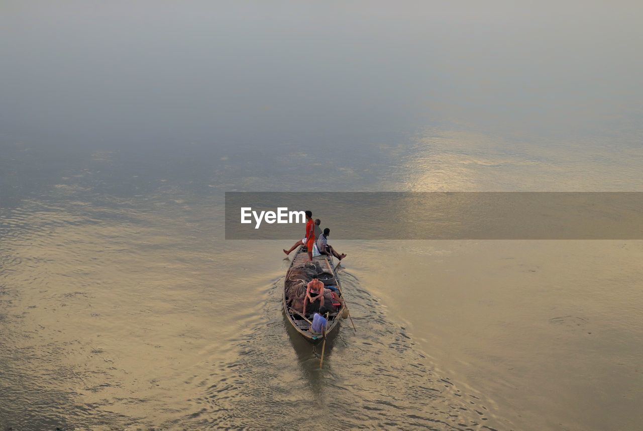 Rear view of people enjoying boat ride in river 