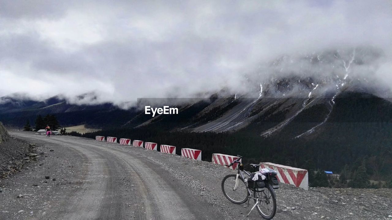Bicycles by mountain on road during foggy weather