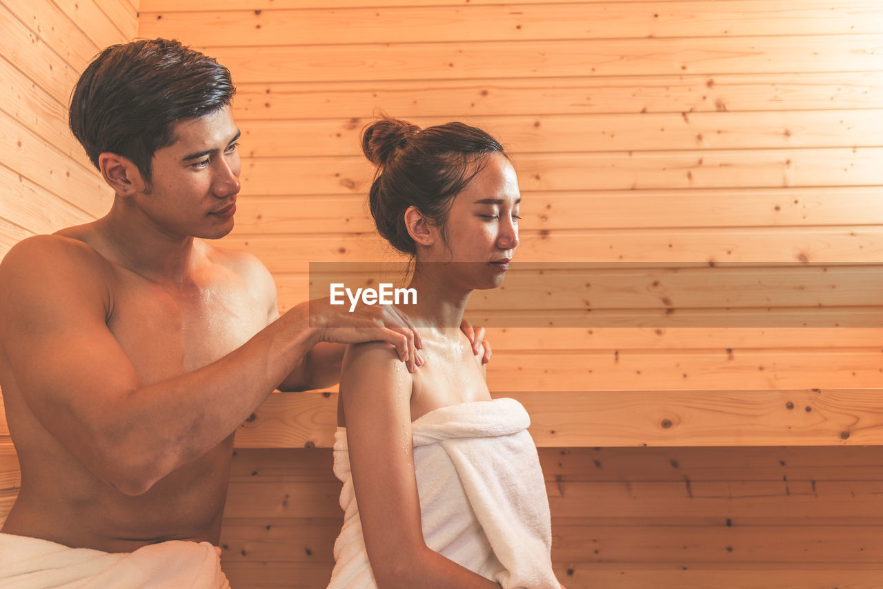 Young couple sitting in sauna