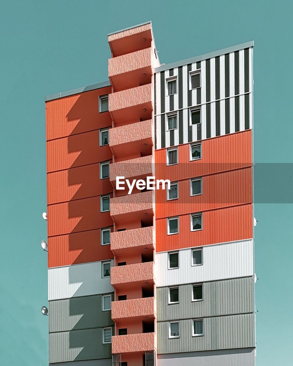 LOW ANGLE VIEW OF APARTMENT BUILDING AGAINST CLEAR SKY
