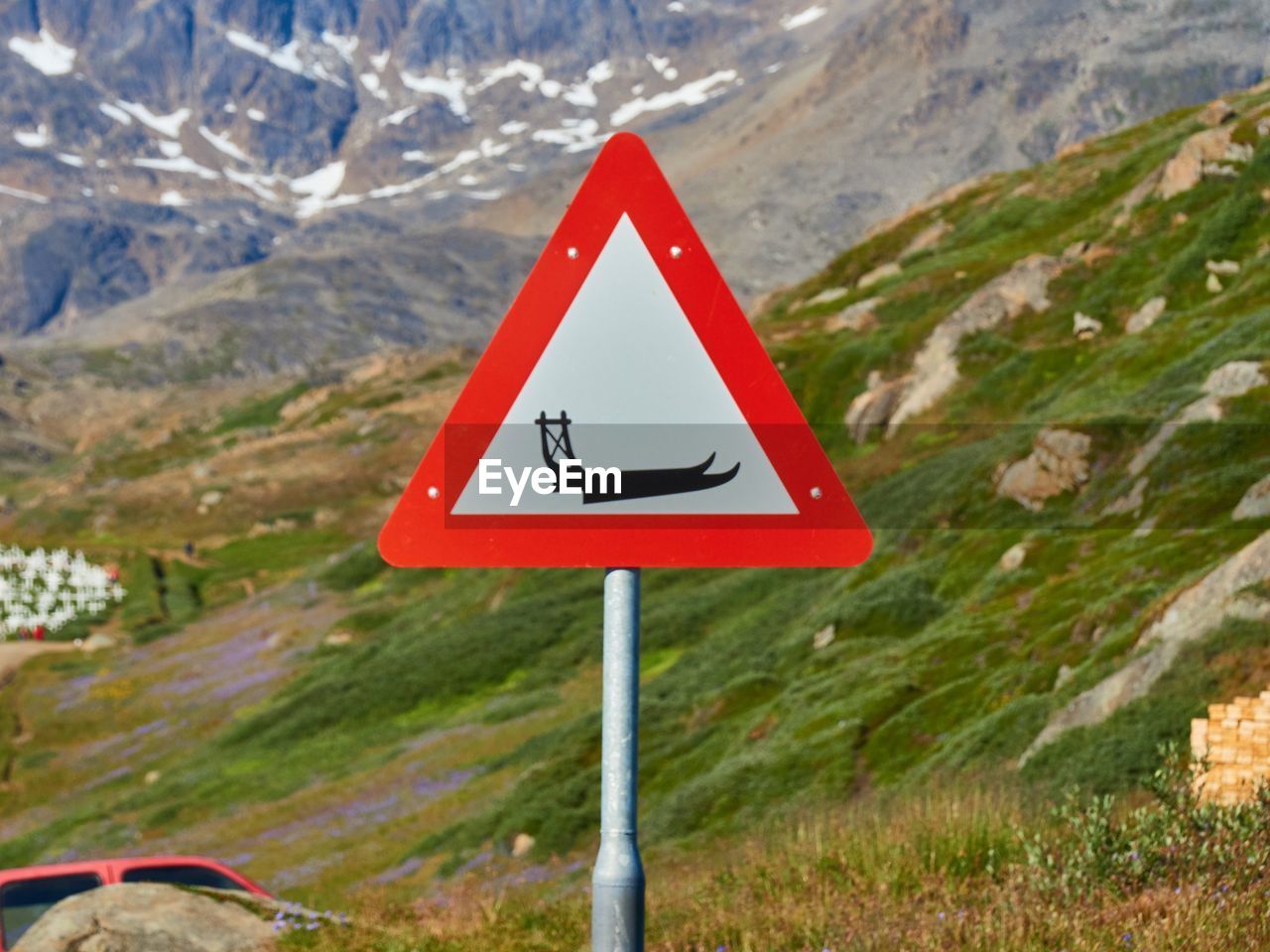 CLOSE-UP OF ROAD SIGN ON LANDSCAPE AGAINST MOUNTAIN