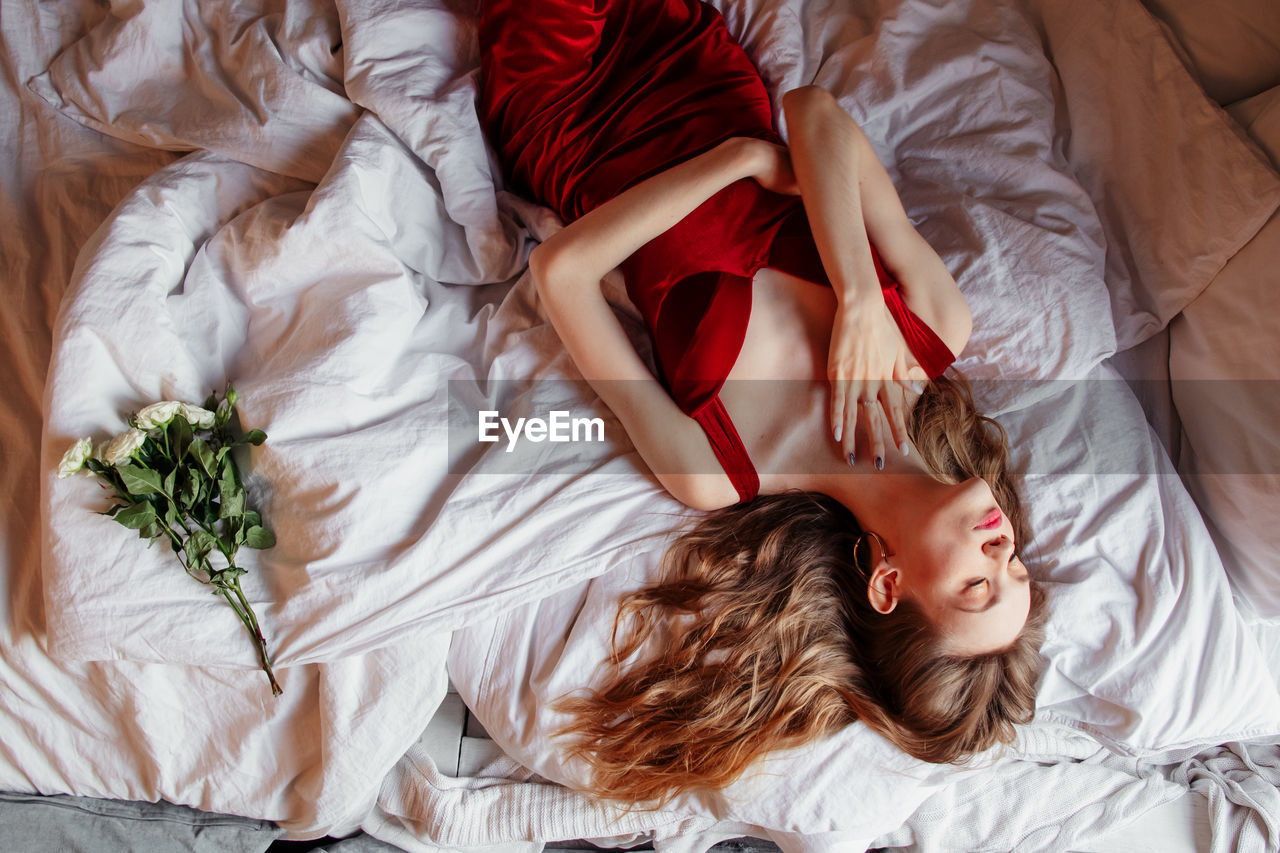 High angle view of woman lying on bed