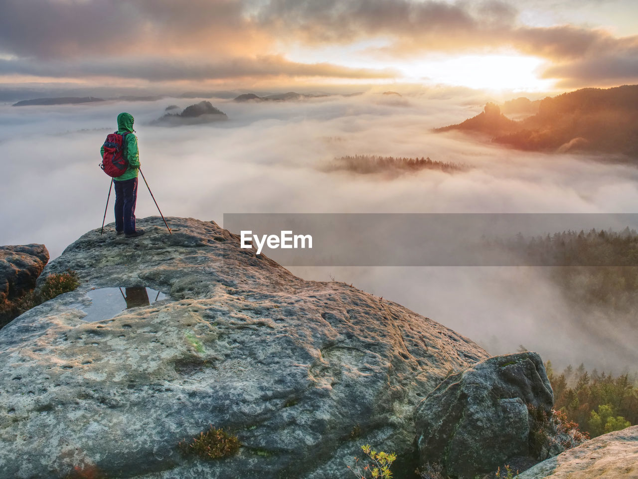Emale hiker enjoying the view on the soutern rim of saxony switzerland within extreme autumn weather