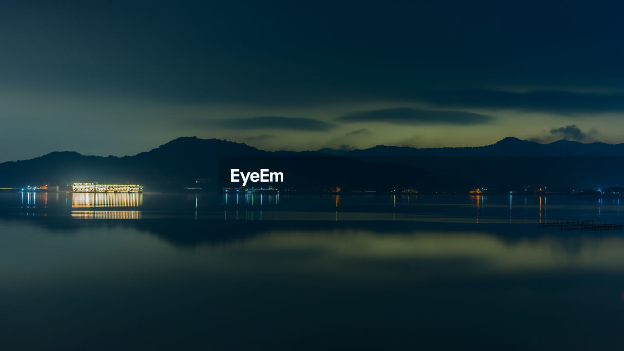 ILLUMINATED LAKE AGAINST SKY AT NIGHT