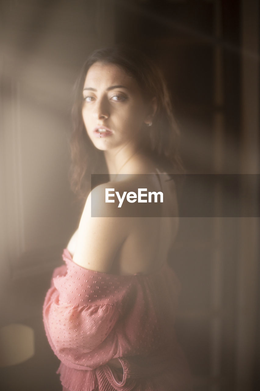 Portrait of beautiful young woman standing at home
