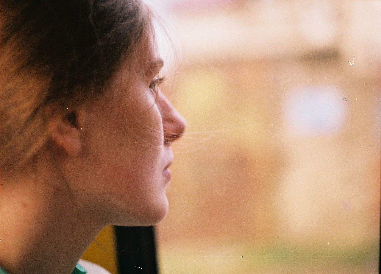 Close-up of woman looking through window