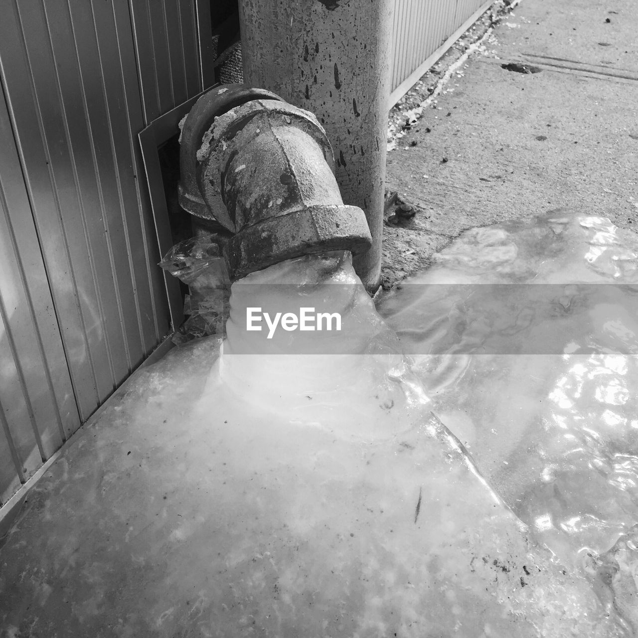 High angle view of frozen water under pipe