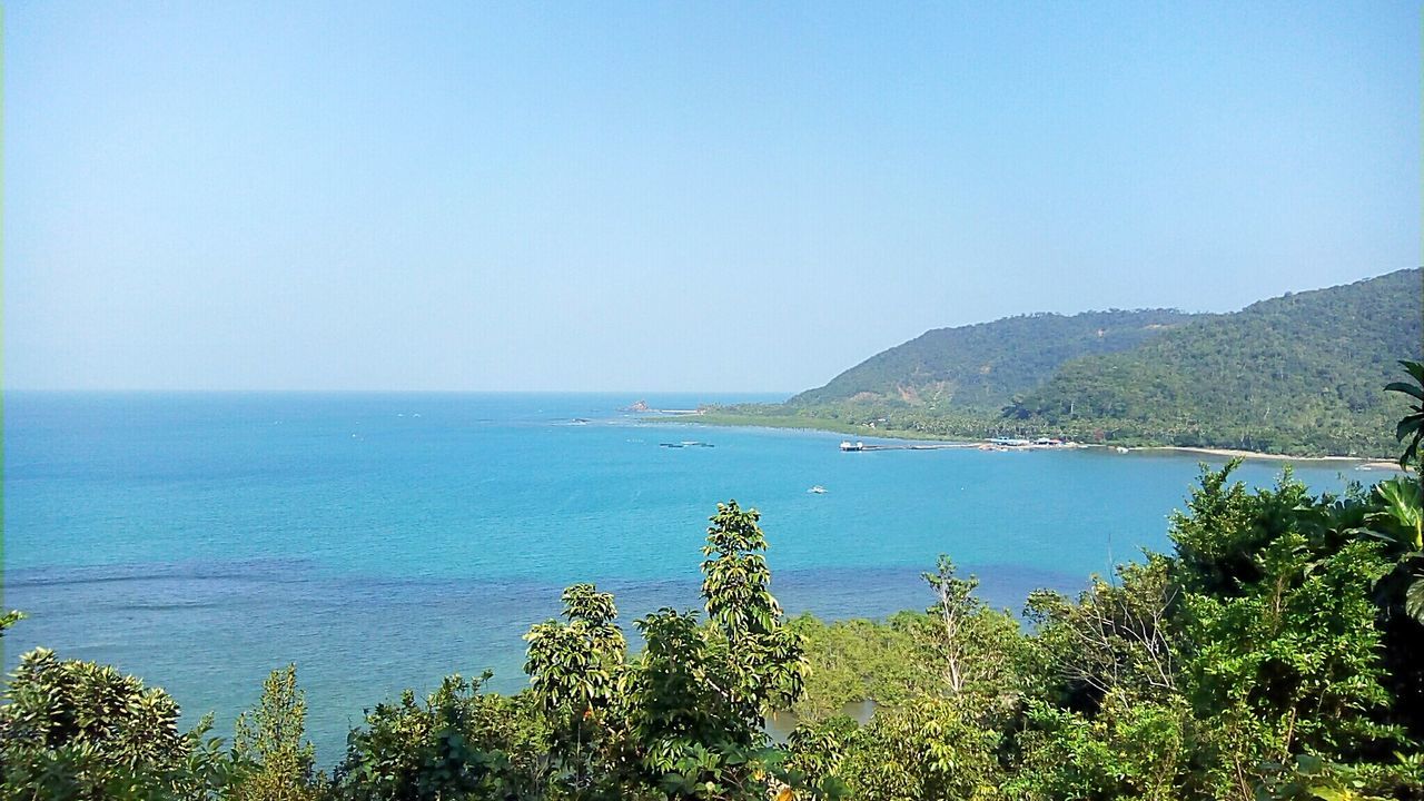 SCENIC VIEW OF SEA AND MOUNTAINS AGAINST CLEAR BLUE SKY