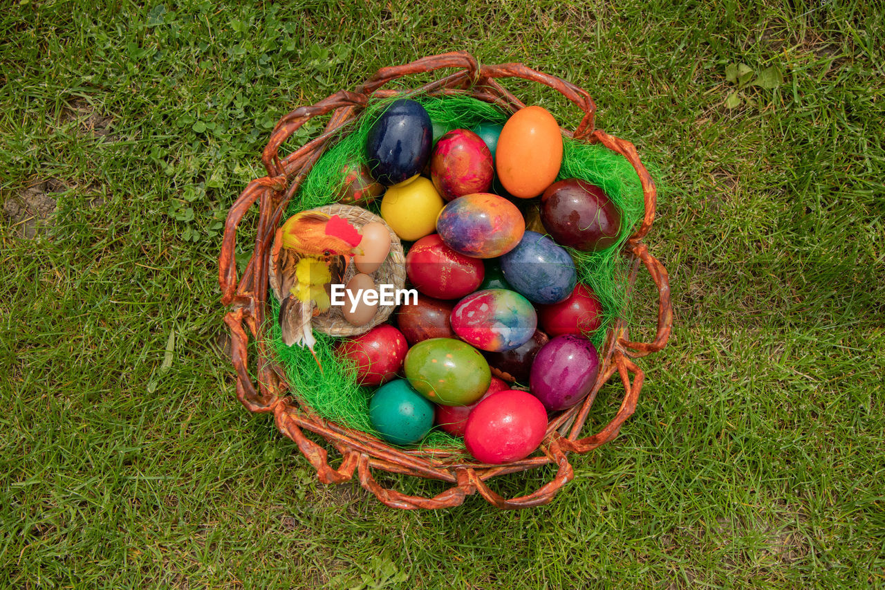 HIGH ANGLE VIEW OF MULTI COLORED EGGS IN BASKET
