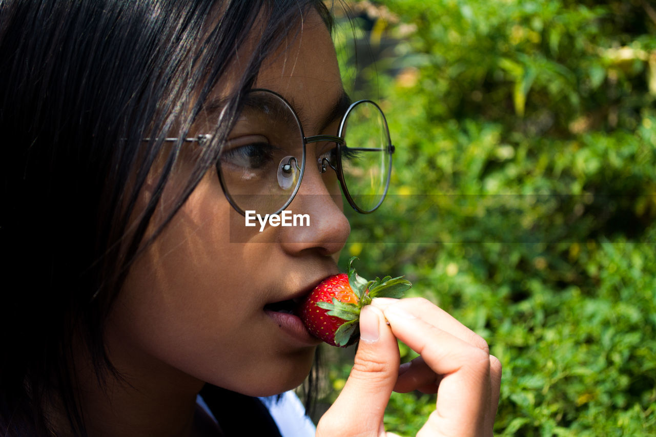 Close-up of girl eating strawberry