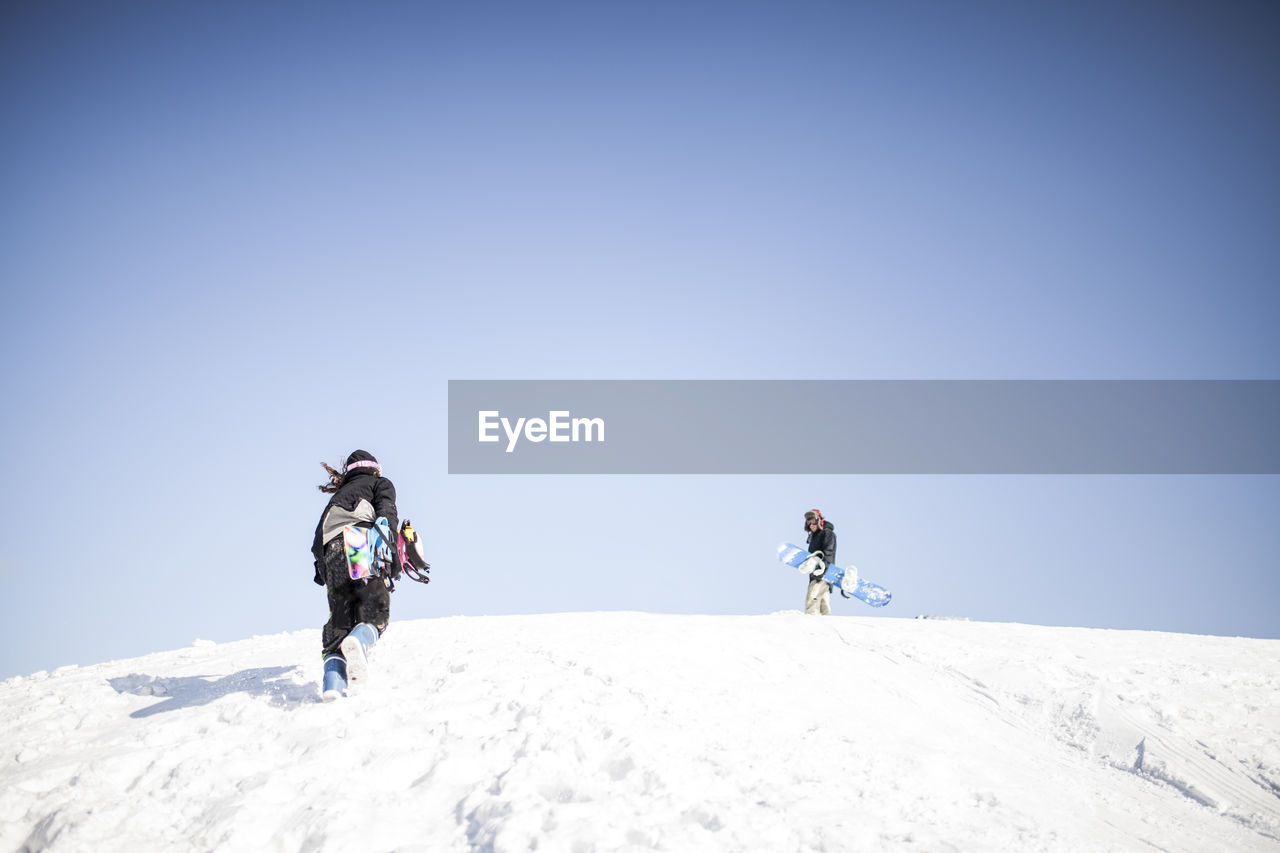 PEOPLE ON SNOWCAPPED MOUNTAIN AGAINST SKY