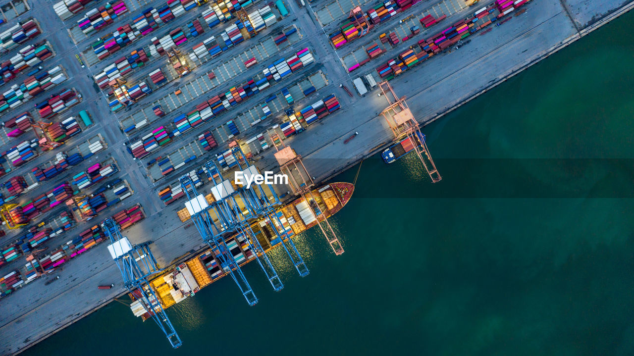 Aerial view container ship loaded in container terminal at night, global business import export