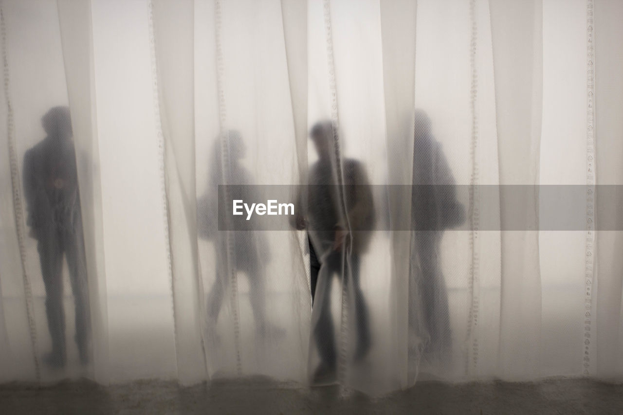 Shadow of people behind curtain
