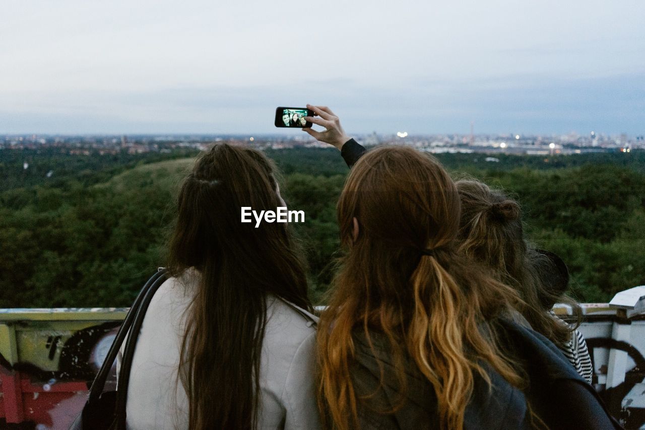 Friends taking a picture of themselves with a mobile phone
