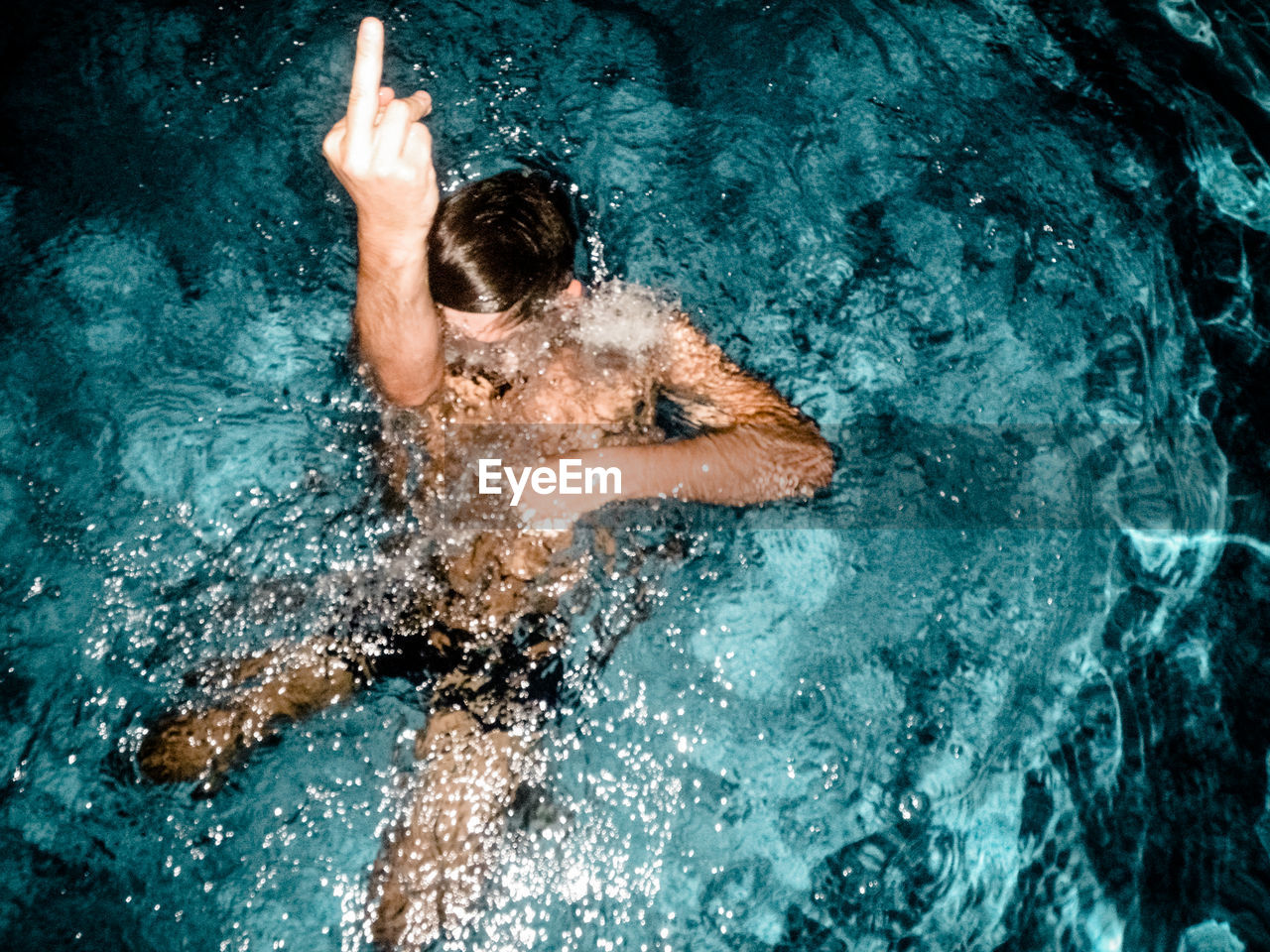 HIGH ANGLE VIEW OF PERSON SWIMMING IN WATER