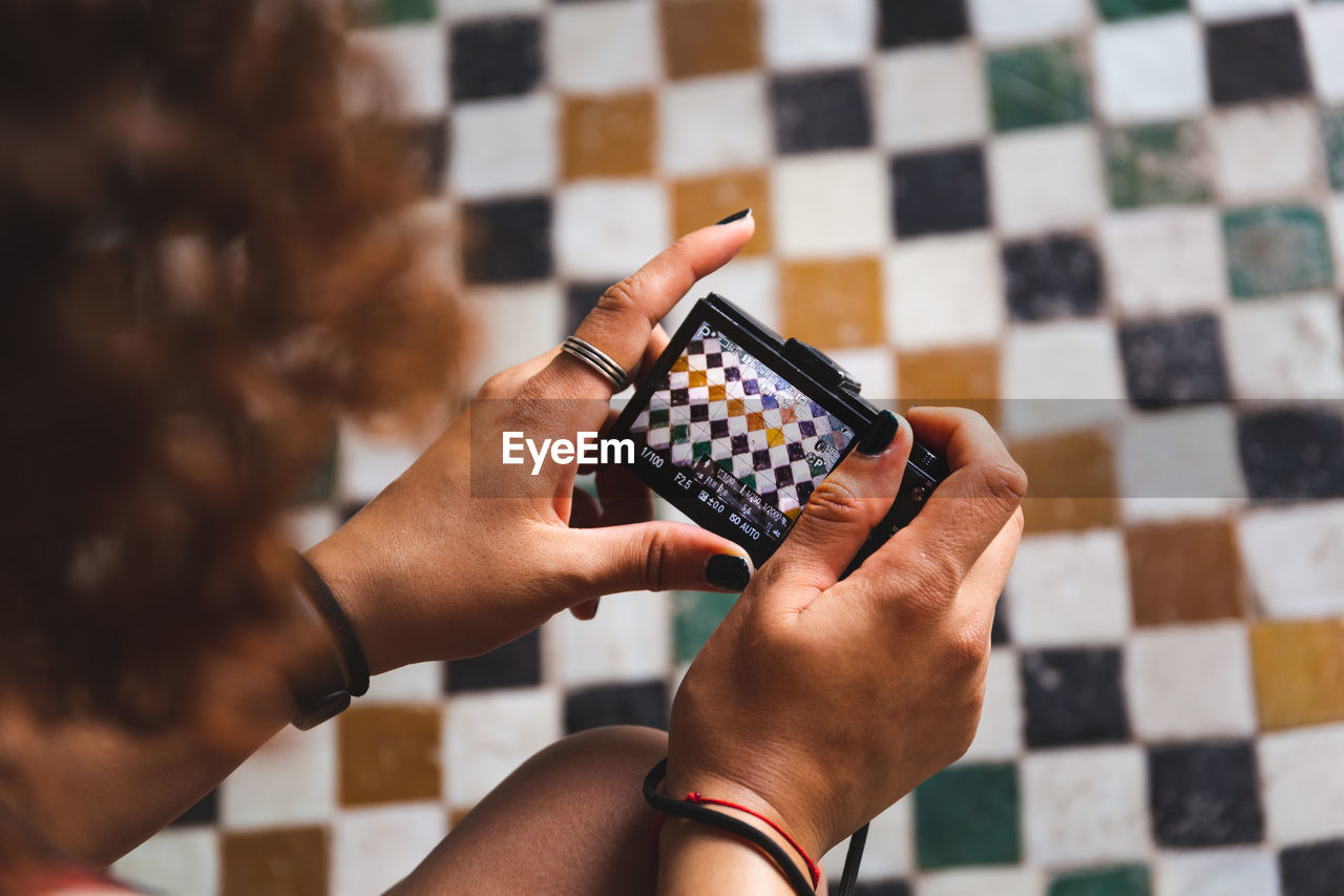 Cropped image of woman photographing tiled floor