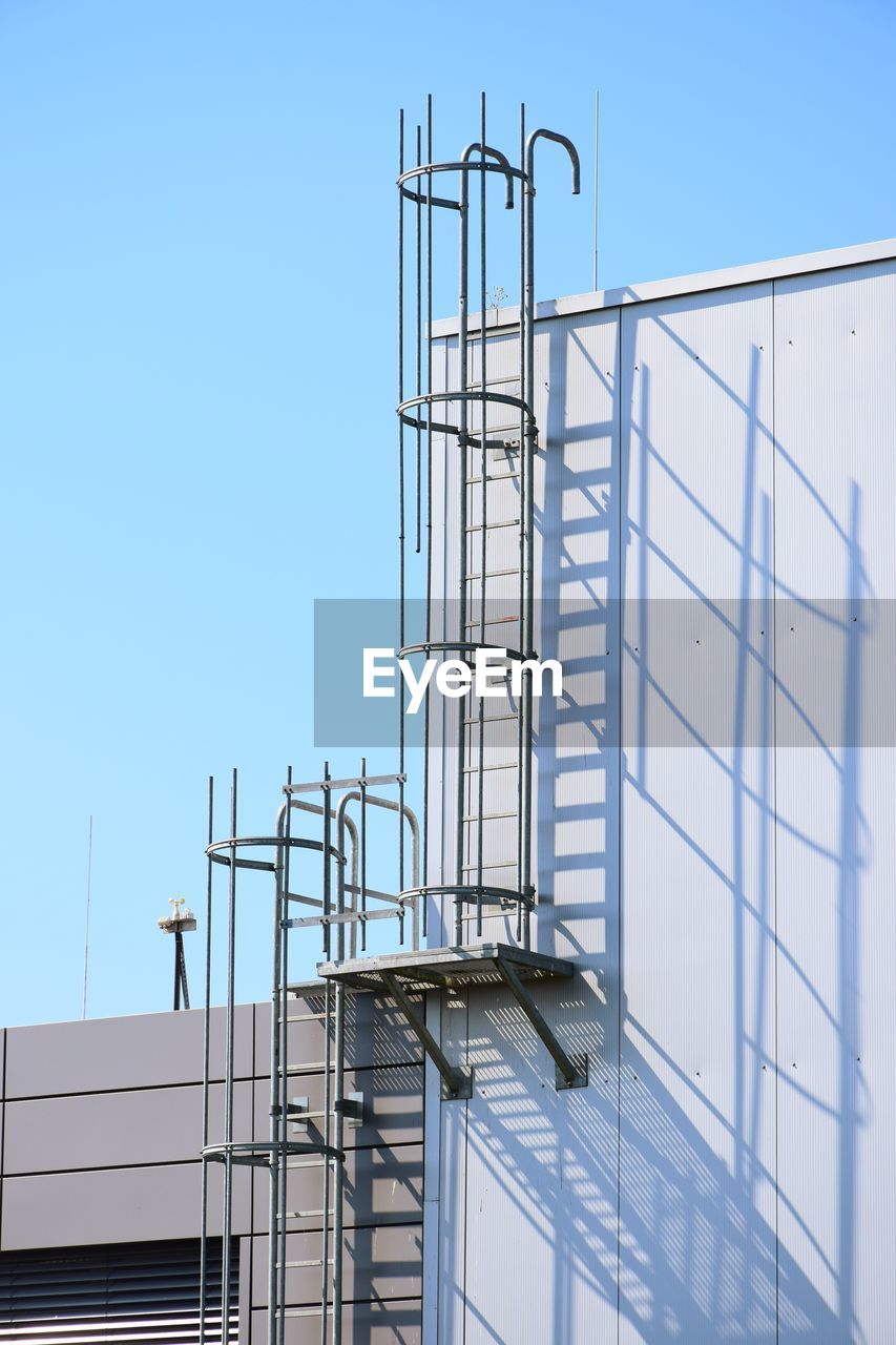 Low angle view of staircase against building against clear blue sky
