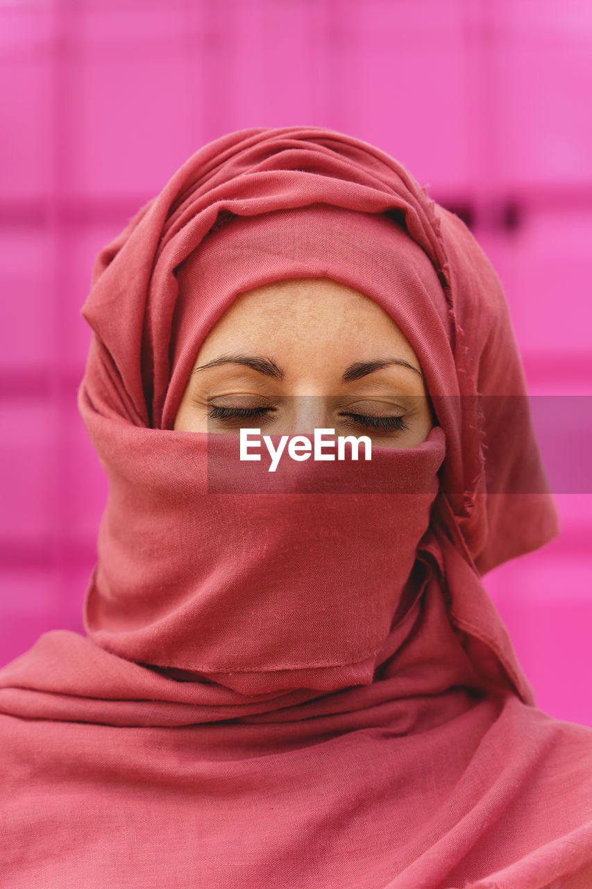 Vertical portrait of muslim woman wearing hiyab with eyes closed. cultural diversity and religion.