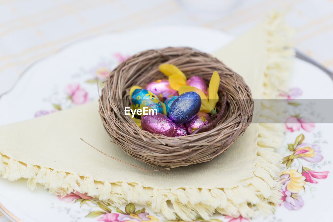 High angle view of multi colored candies in easter bird's nest / basket