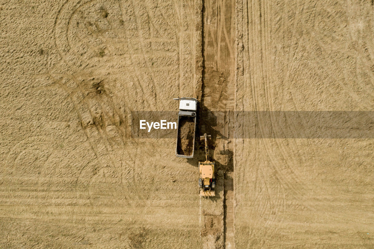 HIGH ANGLE VIEW OF VINTAGE CAR ON FIELD AT FARM