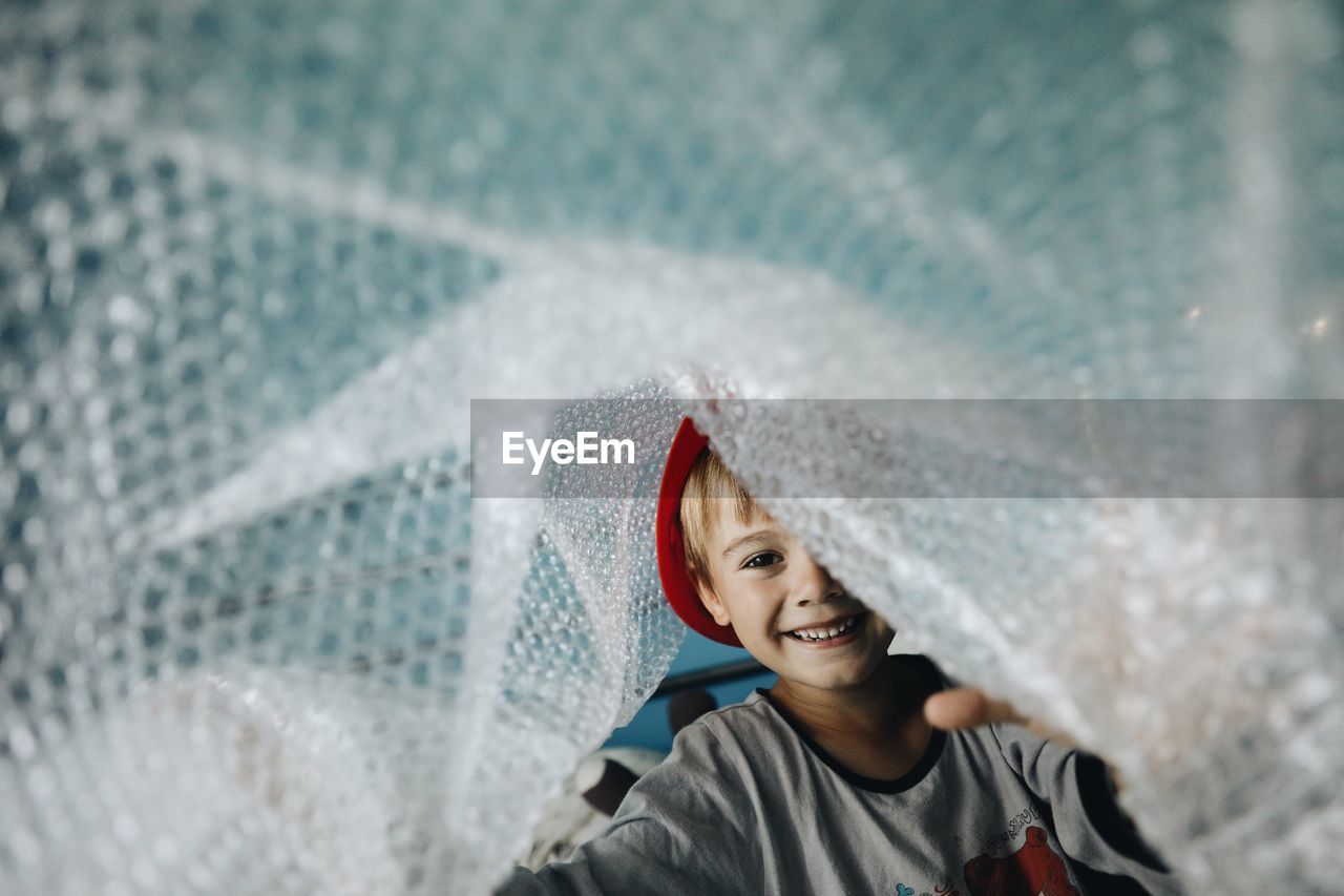 Portrait of boy playing with bubble wrap