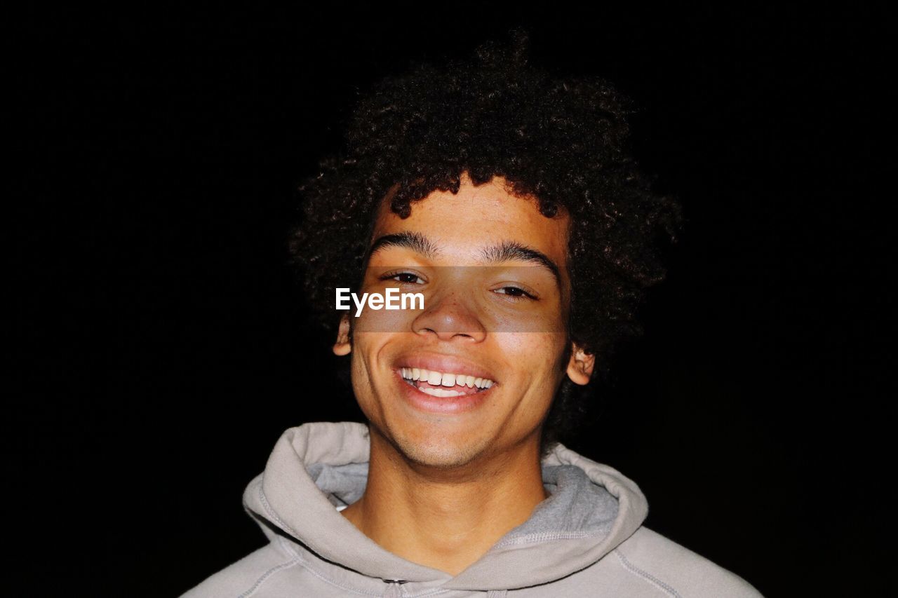 Portrait of a smiling man against black background