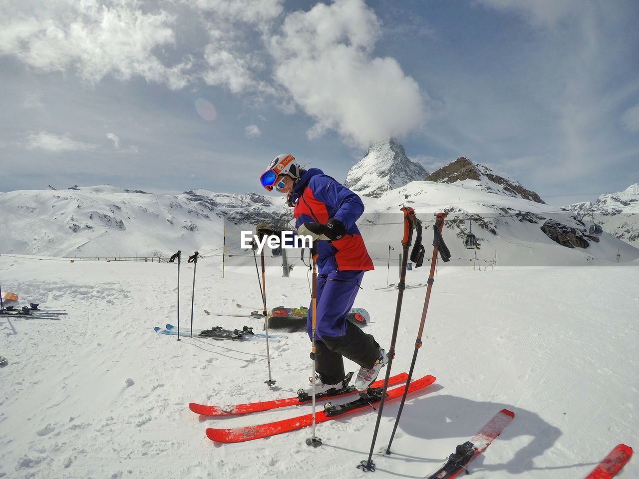 PEOPLE SKIING ON SNOWCAPPED MOUNTAINS AGAINST SKY