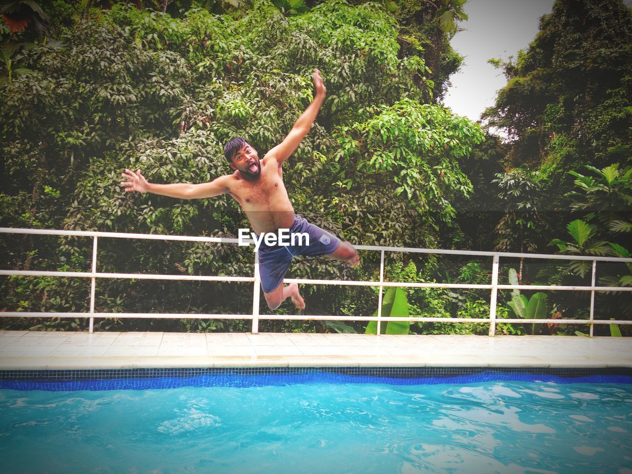 Mid adult man diving into swimming pool