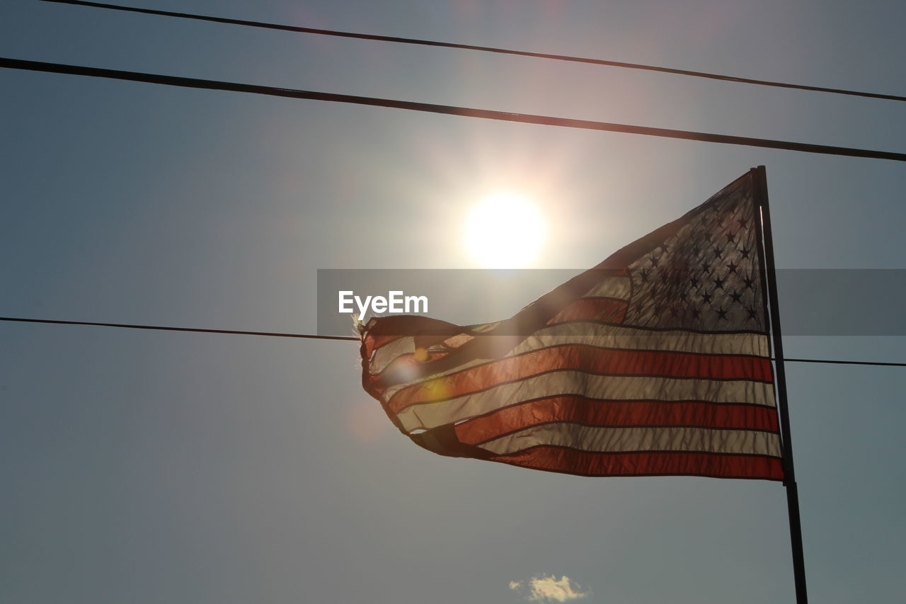 LOW ANGLE VIEW OF AMERICAN FLAG AT SUNSET