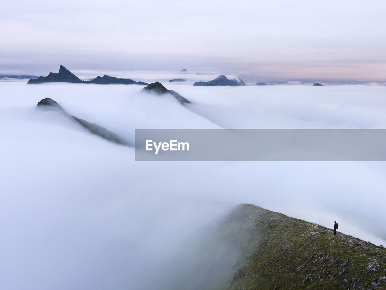 Man in foggy mountain landscape at sunrise