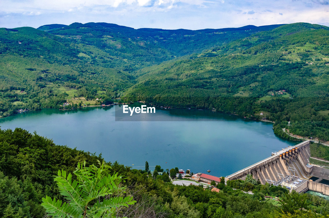 HIGH ANGLE VIEW OF LAKE AMIDST TREES AND MOUNTAINS