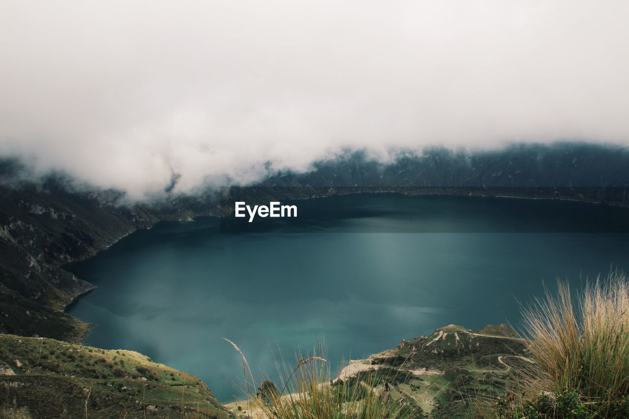Scenic view of crater lake against cloudy sky