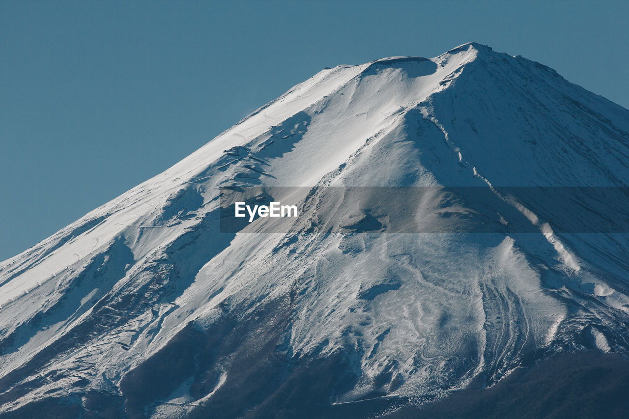 AERIAL VIEW OF SNOWCAPPED MOUNTAIN AGAINST CLEAR SKY