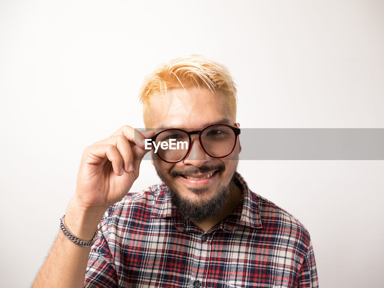 PORTRAIT OF MAN WEARING EYEGLASSES AGAINST GRAY BACKGROUND
