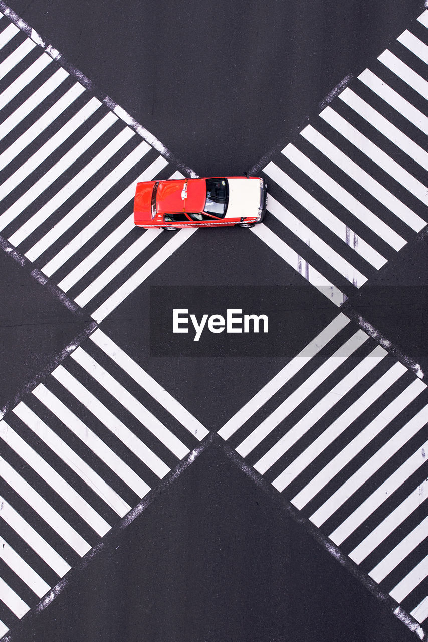 High angle view of car on intersecting pedestrian crossings