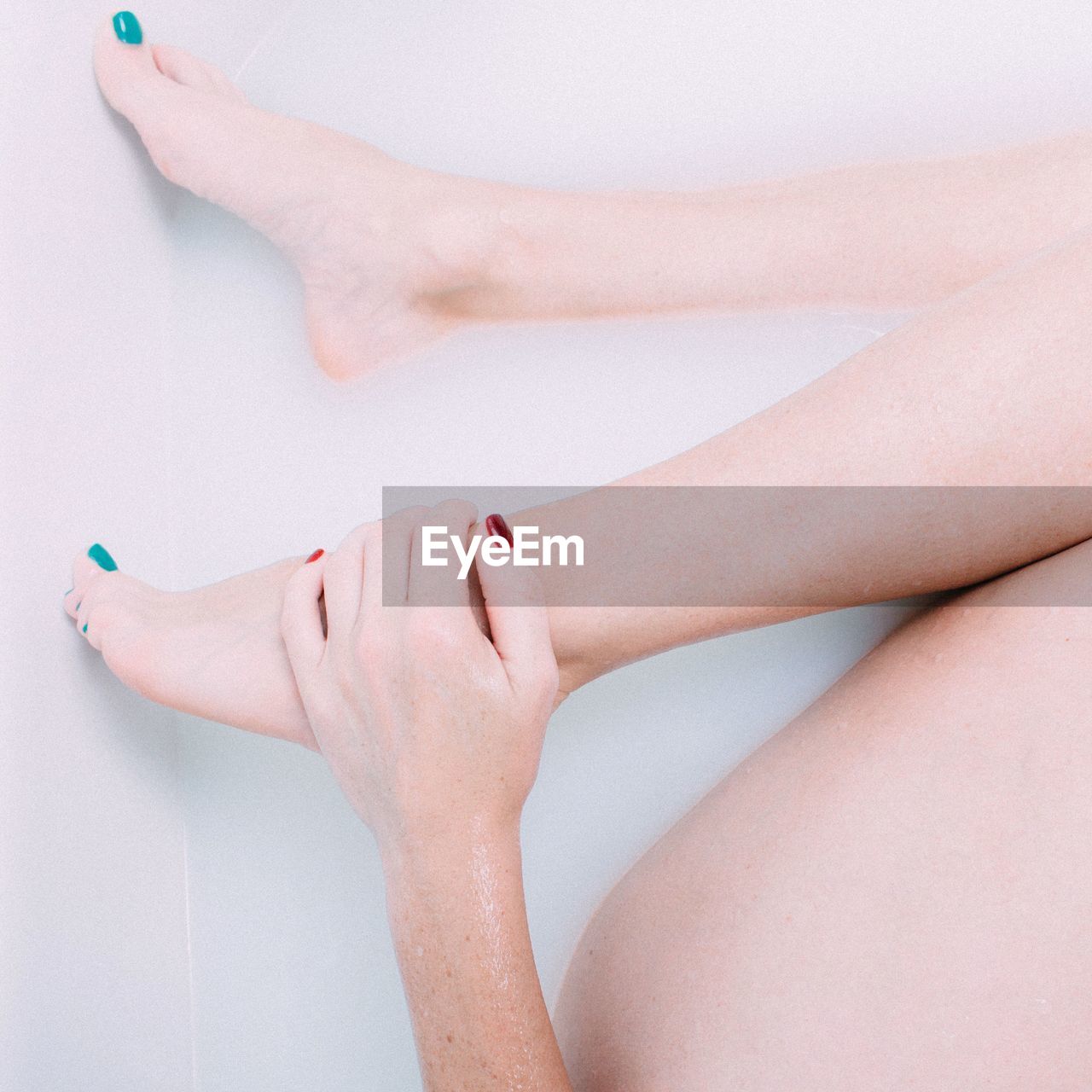 Cropped image of naked women on white background