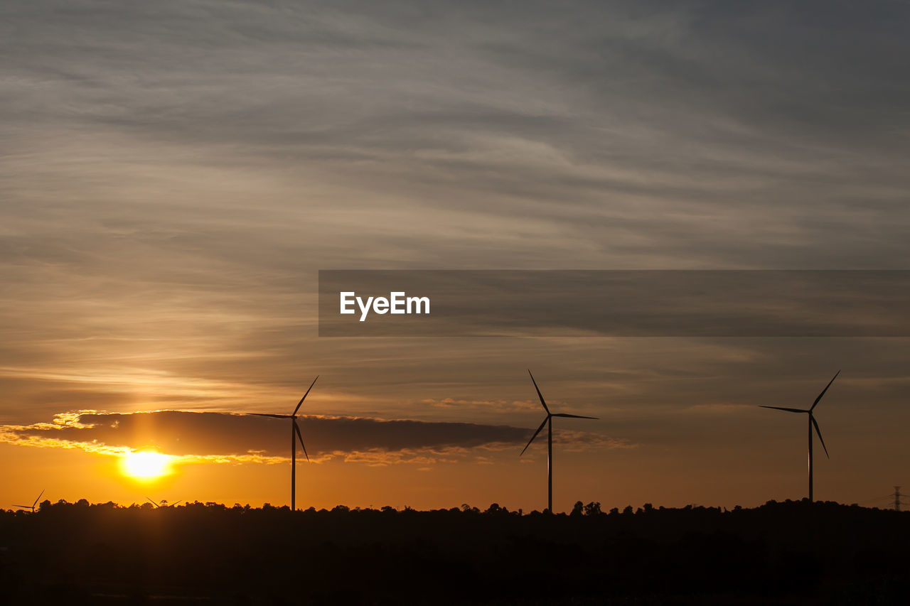 SILHOUETTE OF WIND TURBINES AT SUNSET
