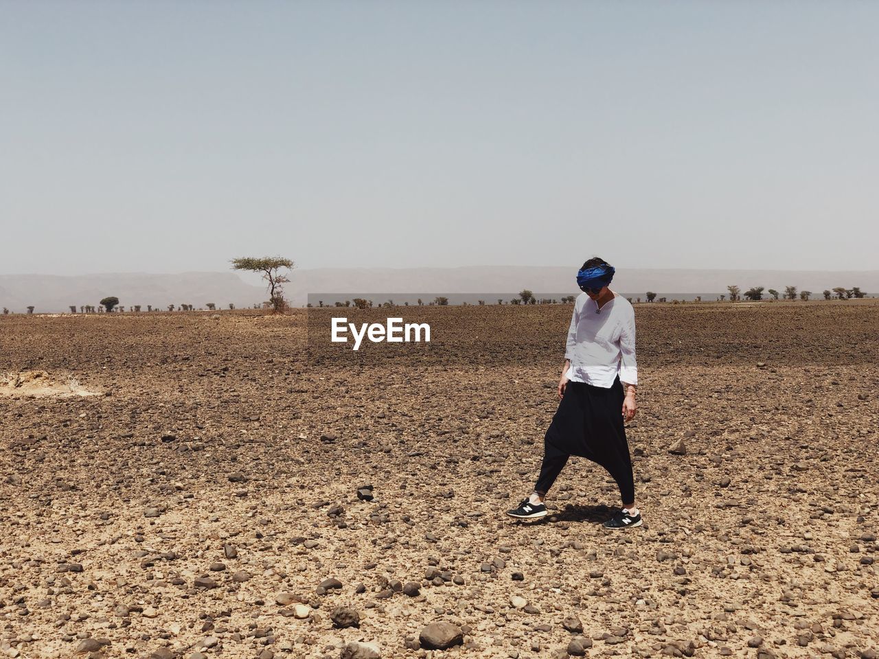 Full length of woman standing on desert against clear sky