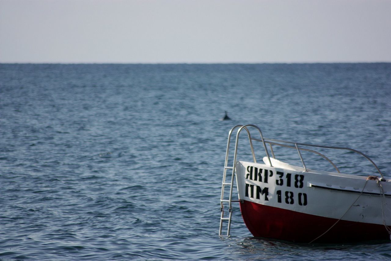 Cropped image of motorboat on sea against clear sky