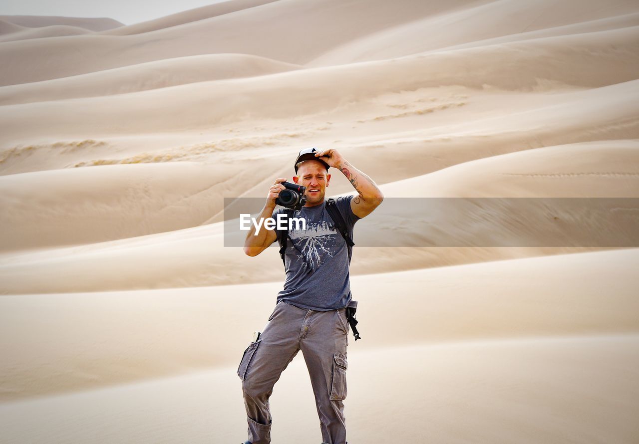 Man photographing from camera at desert