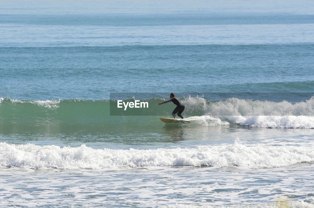 MAN SURFING IN SEA WAVES